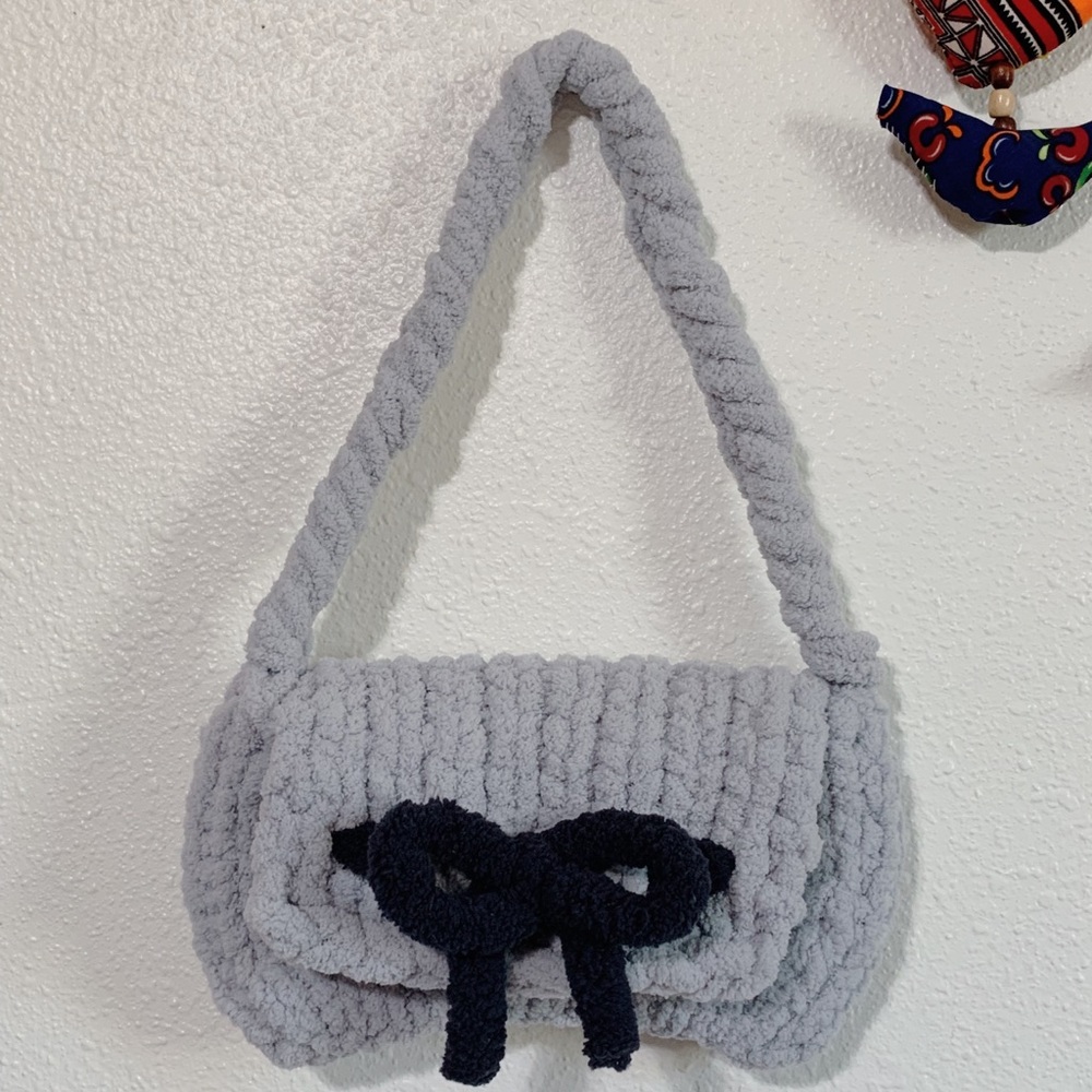 Soft hand-knitted purse with strap and snap closure